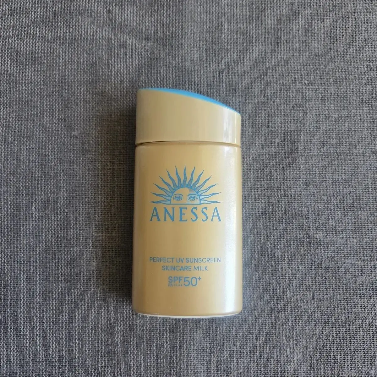 アネッサのパーフェクトUVサンケアミルクSPF50+。黄色のボトルで、中央に日の丸のようなロゴとブランド名が記載されている。