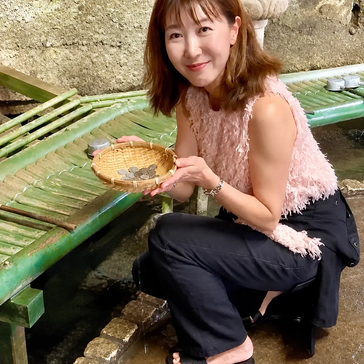 銭洗いのザルを持って。中には小銭。