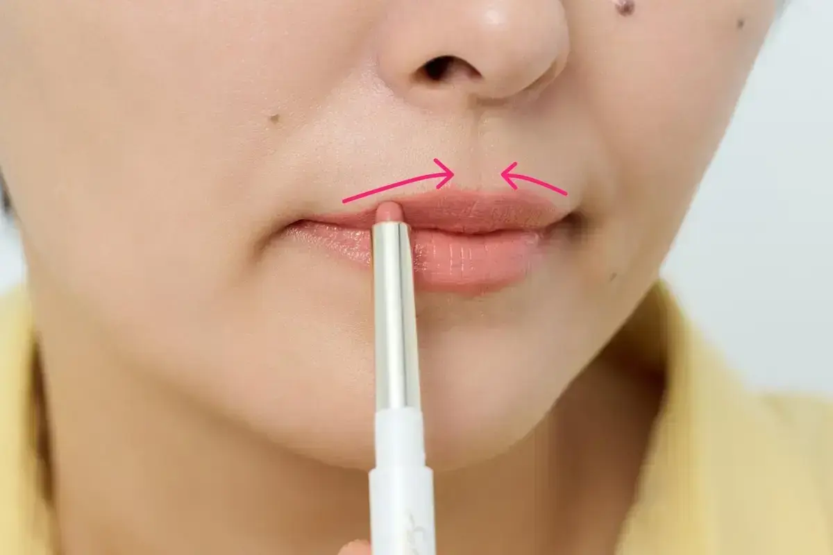 リップライナーでリップの輪郭をなぞります。こうすると色が落ちにくくなり、顔がぼやけません