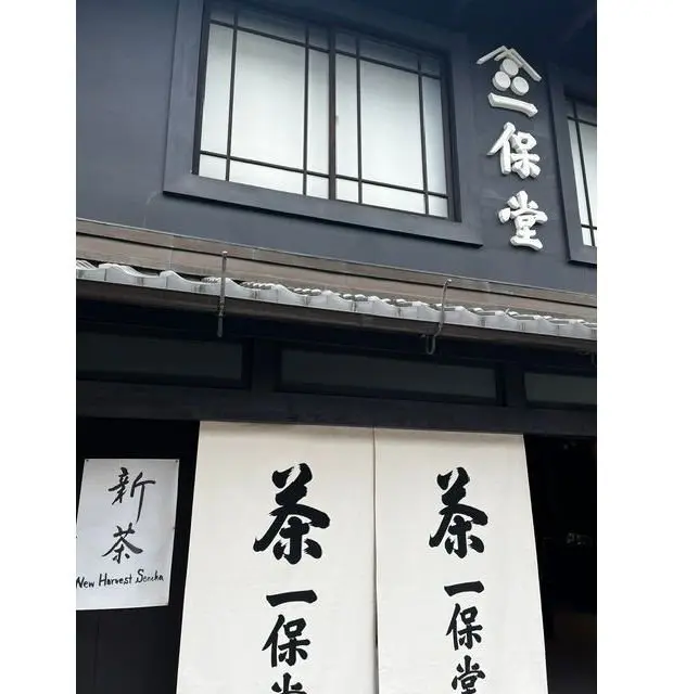 黒い建物の外観で、左側に「新収穫寿司」の看板、右側に「小倉寿司」の看板が設置されている
