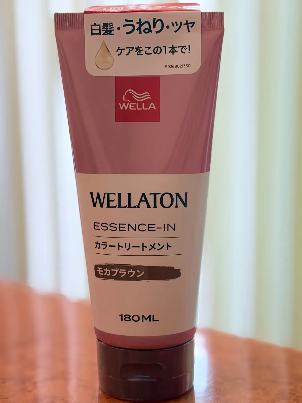 ウェラトンのエッセンスインカールリートリートメント、180ml。ピンクと茶色のチューブで、白いラベルに「白髪・うねり・ツヤ」の文字とオイルのイラスト。ロゴはウェラ。