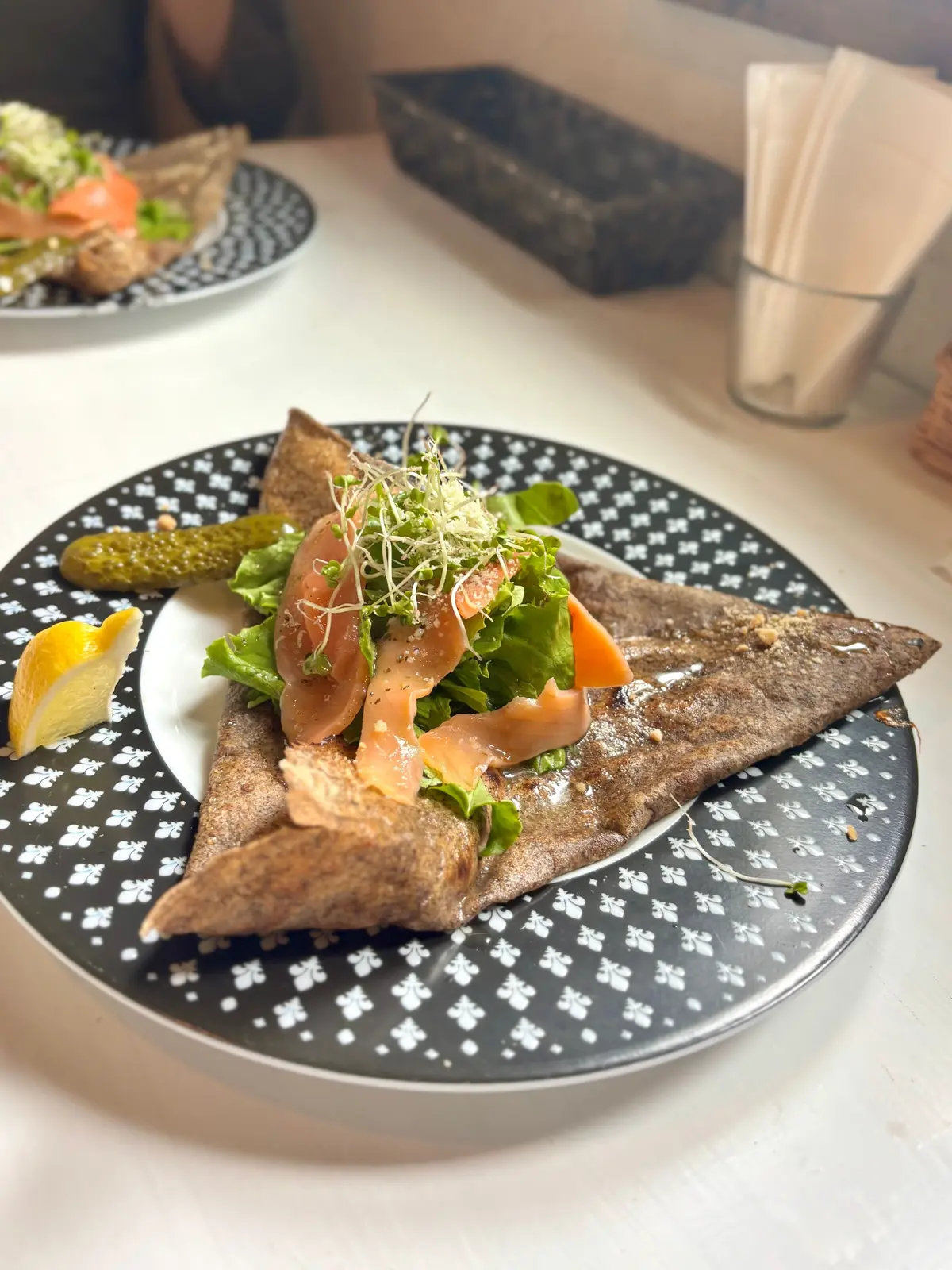 カフェドラフェットのサーモンのガレット。ピクルスとレモンのスライスも添えられています。