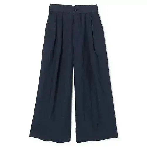 濃紺のワイドレッグパンツ。ハイウエストで、フロントにプリーツが施されている。裾に向かって緩やかに広がったシルエット。