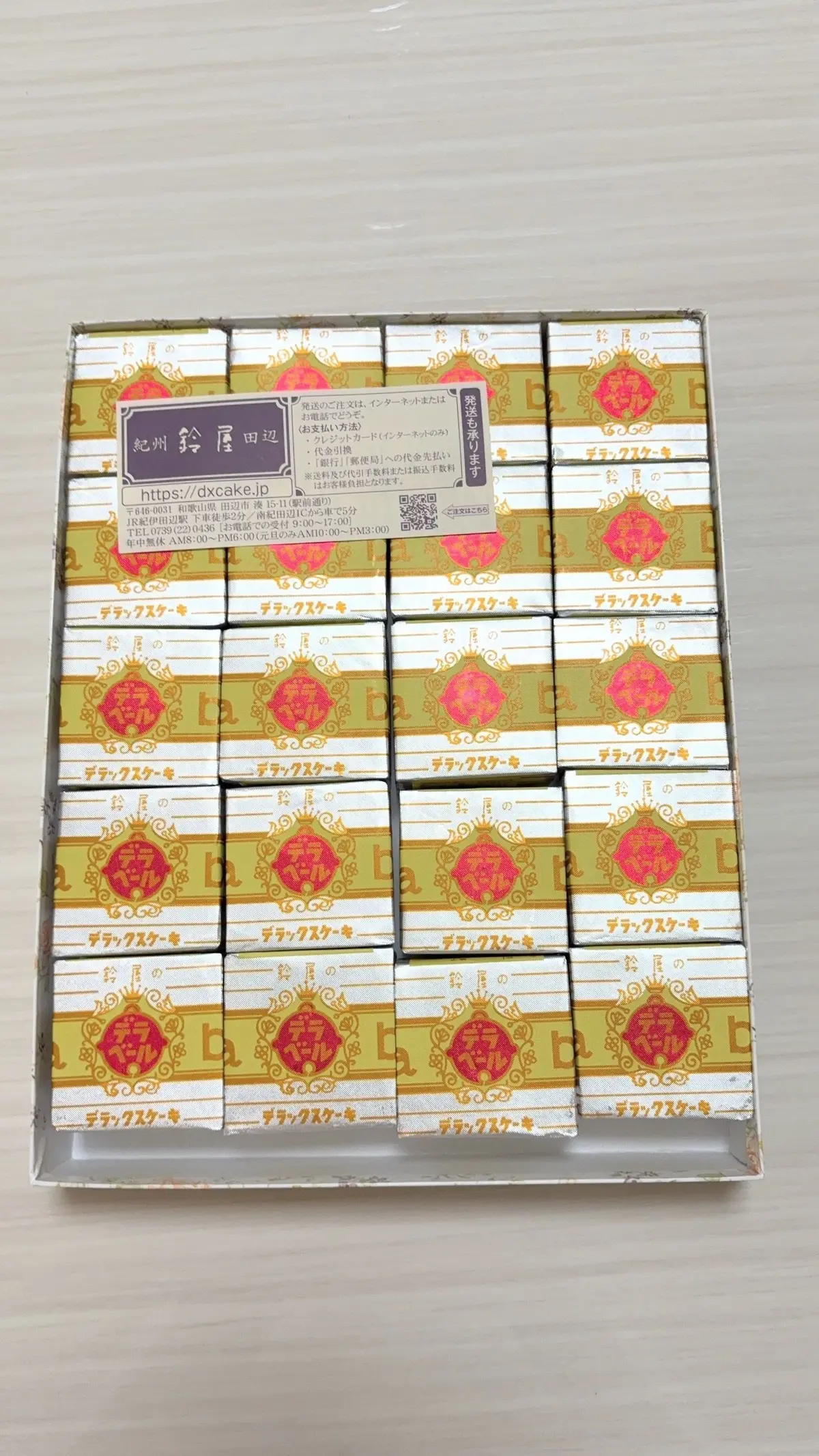 金と赤の和菓子が12個入った箱で、伝統的なデザインが施されている