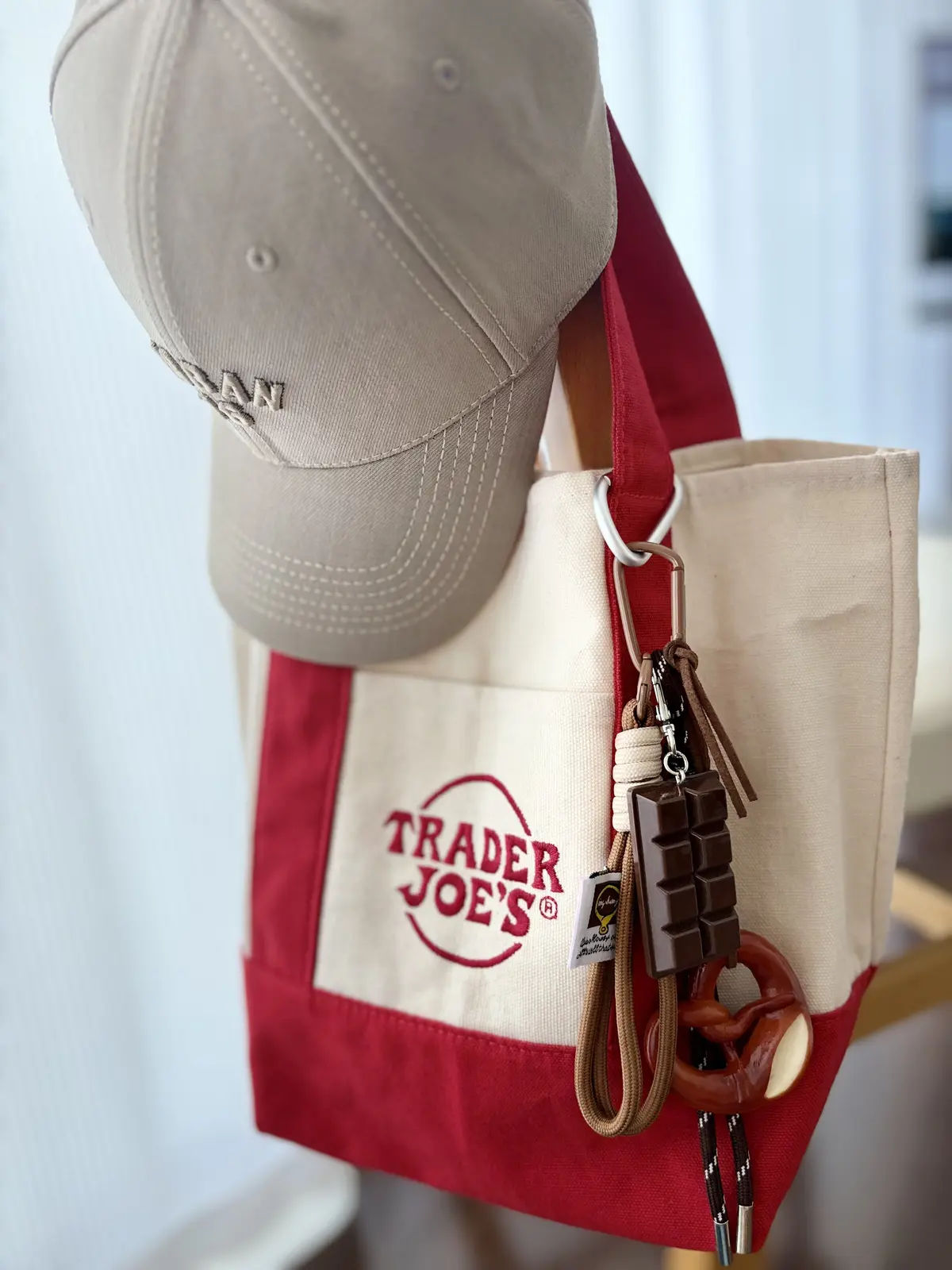 Trader Joe’sミニトートバッグにバッグチャームを付けた写真。韓国風キーリングやドイツ風チャームを合わせた大人カジュアルなエコバッグアレンジ。