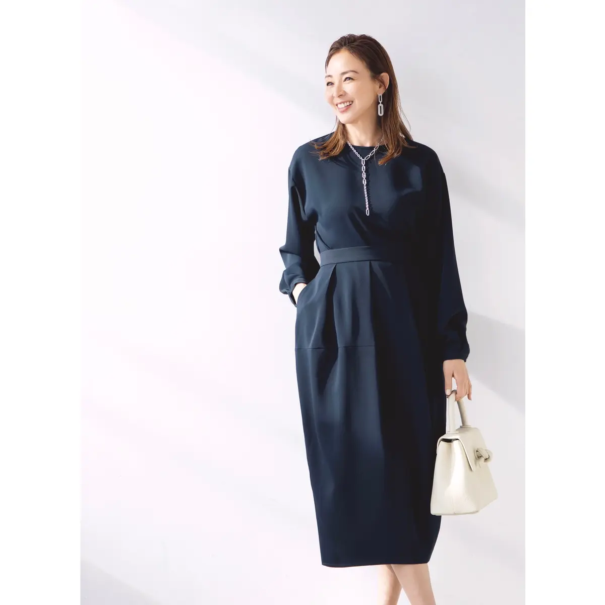 ネイビーのワンピースに白バッグを添えたコーディネート　モデル・SHIHO