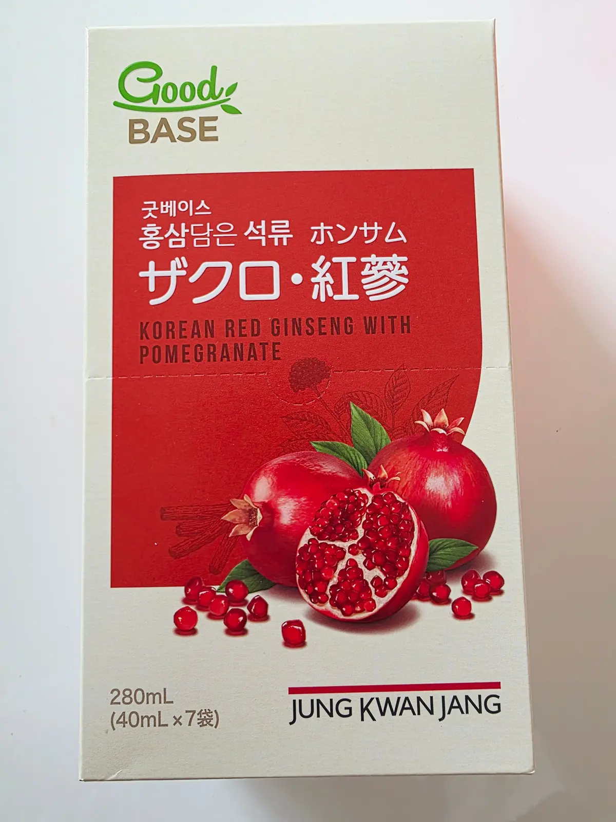 赤い背景に、カットされたザクロとシナモンが描かれた箱。Good Baseのロゴが上部にあり、「Korean Red Ginseng with Pomegranate」と英語で表記。下部に「Jung Kwan Jang」の文字。