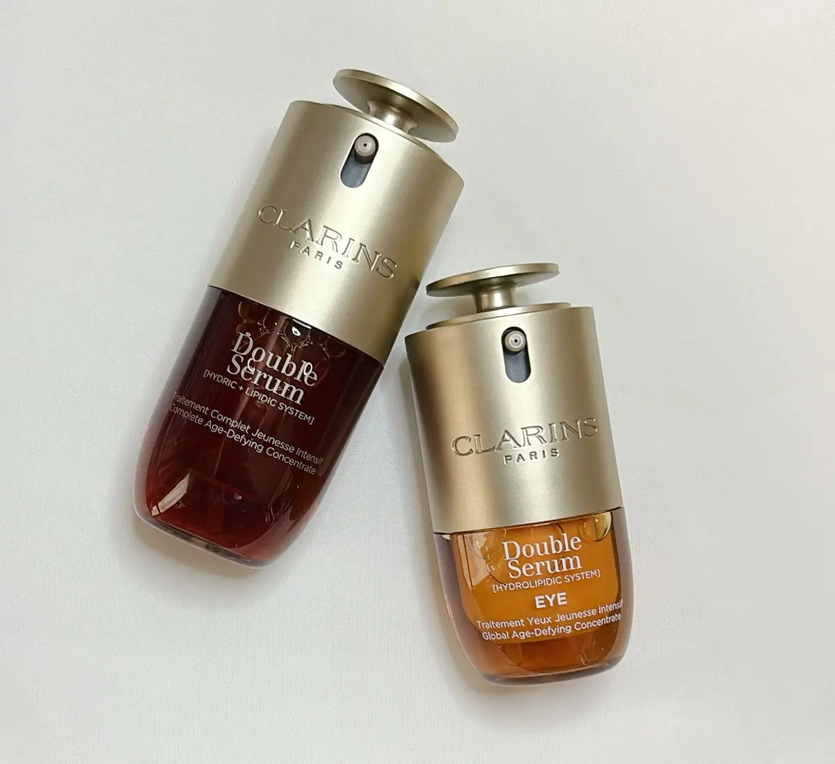 クラランスの「ダブルセラム」美容液2本セット。左は顔用、右は目用。それぞれ金色のボトルで、中央にブランドロゴと製品名が記載されている。