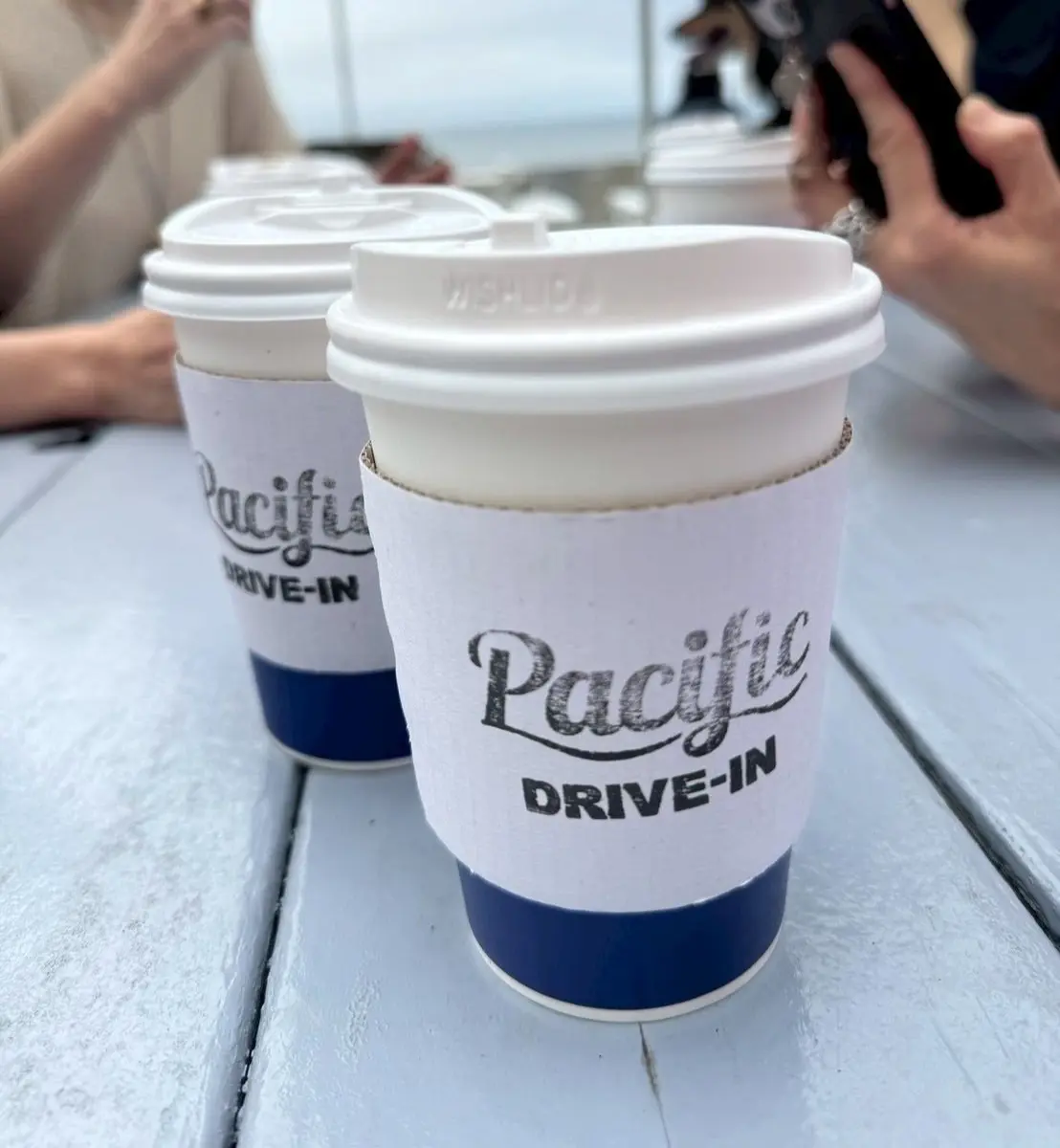 Pacificドライブインのロゴが入った白と青のコーヒーカップが2つ並んでいる