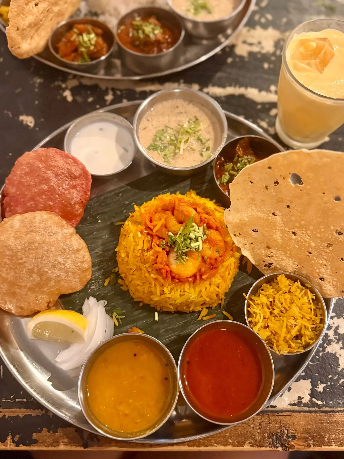 黄色いカレーとパン、さまざまなソースが並ぶインド料理のプレート