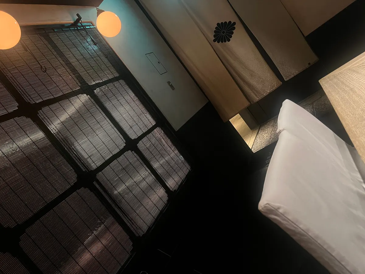 和室の簡易ベッド、すのこベッド、木製テーブルと丸い照明が配置された落ち着いた空間
