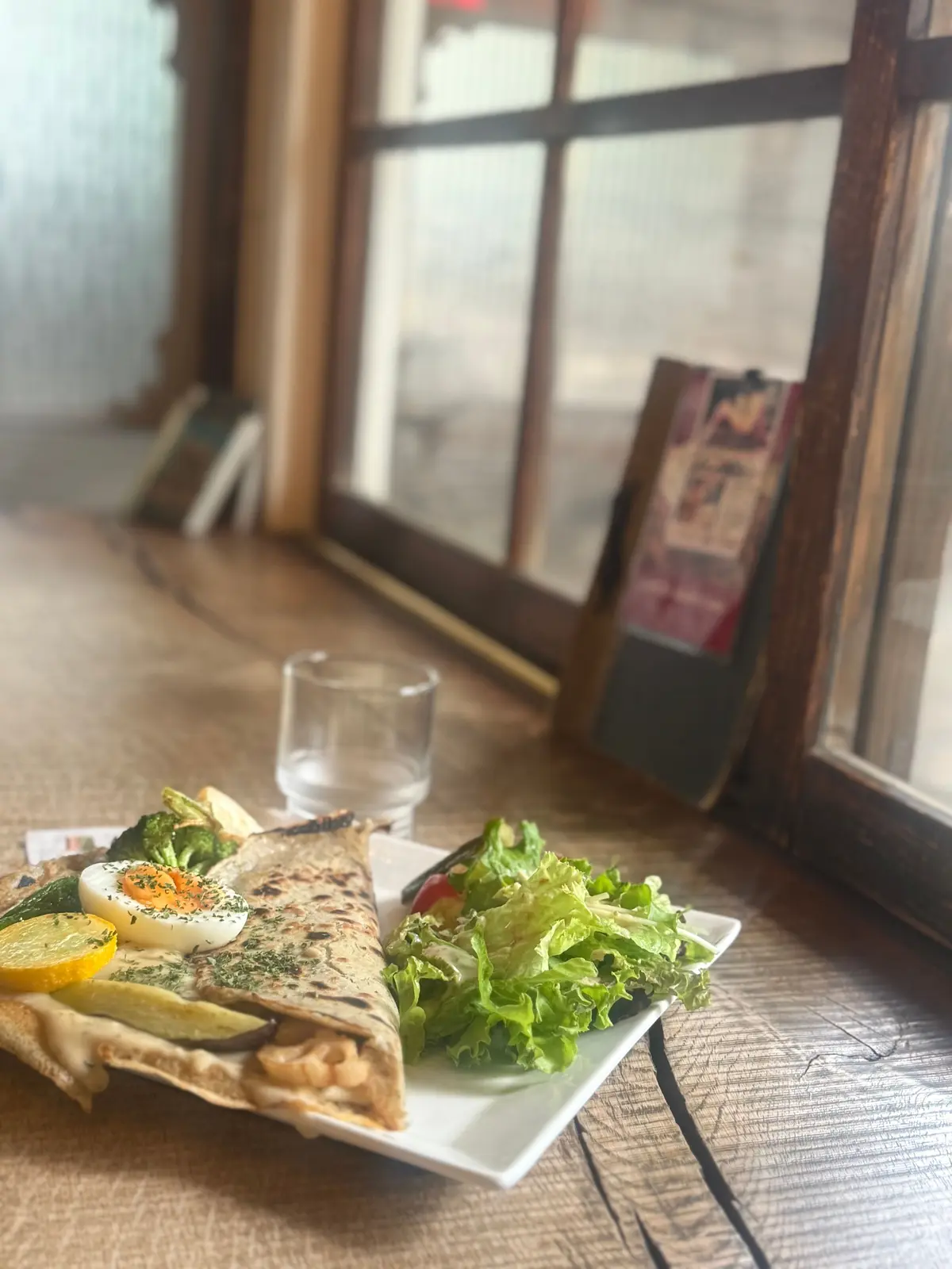 ワンプレートに、野菜とエッグをトッピングしたラップと、フレッシュなレタスのサラダが並ぶ。