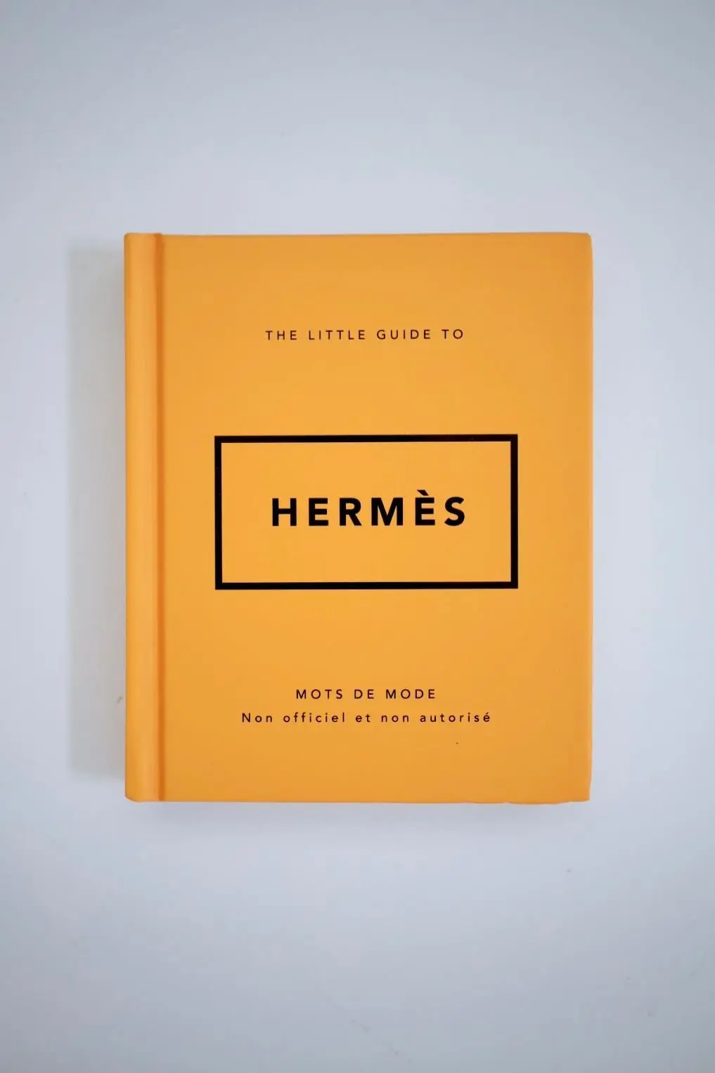 黄色の表紙に黒い四角形で「HERMÈS」の文字が配置された本。上部に「THE LITTLE GUIDE TO」と記載。可愛い本。