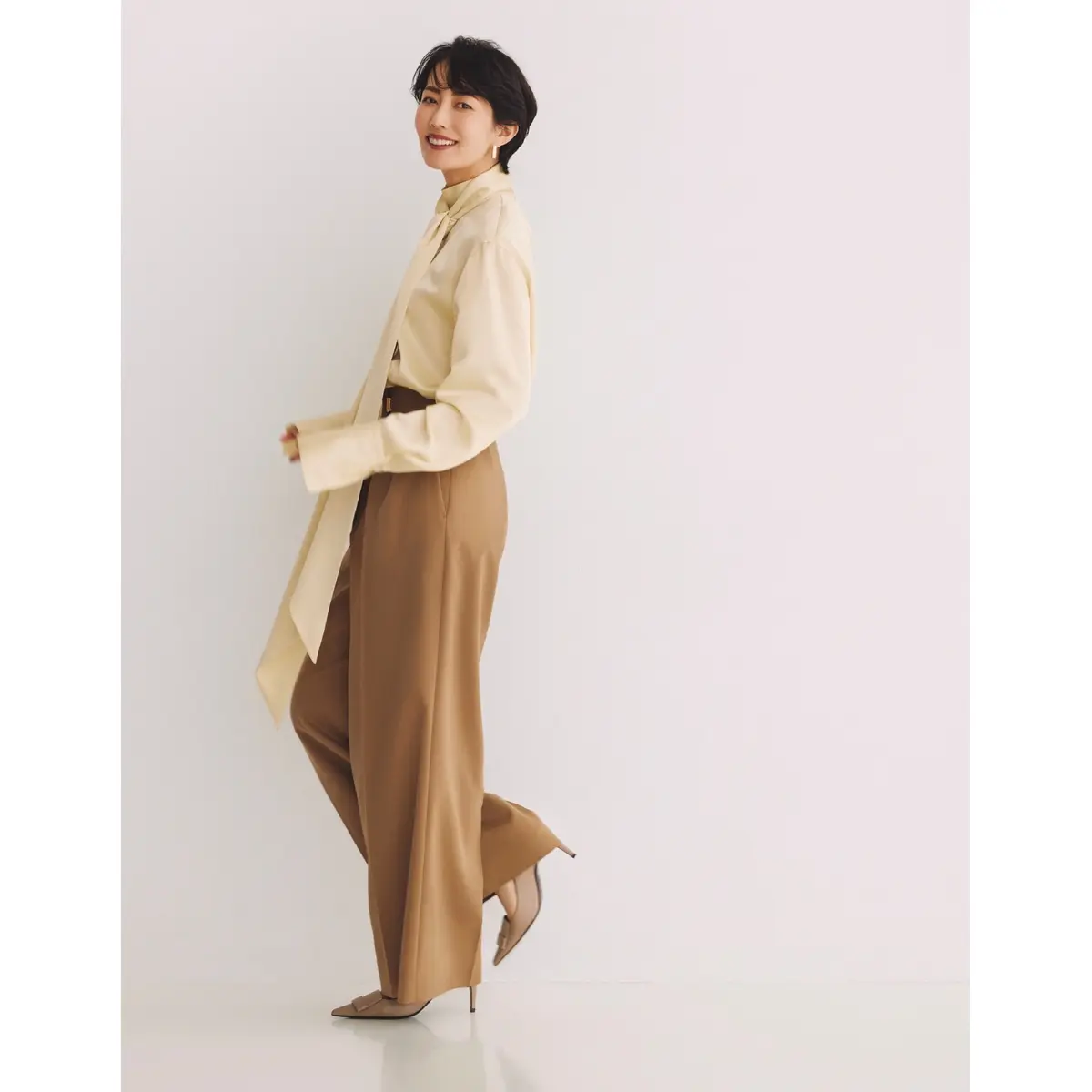 アイボリーのボウタイブラウスにキャメルベージュのワイドパンツを合わせたコーディネート　モデル・松田珠希