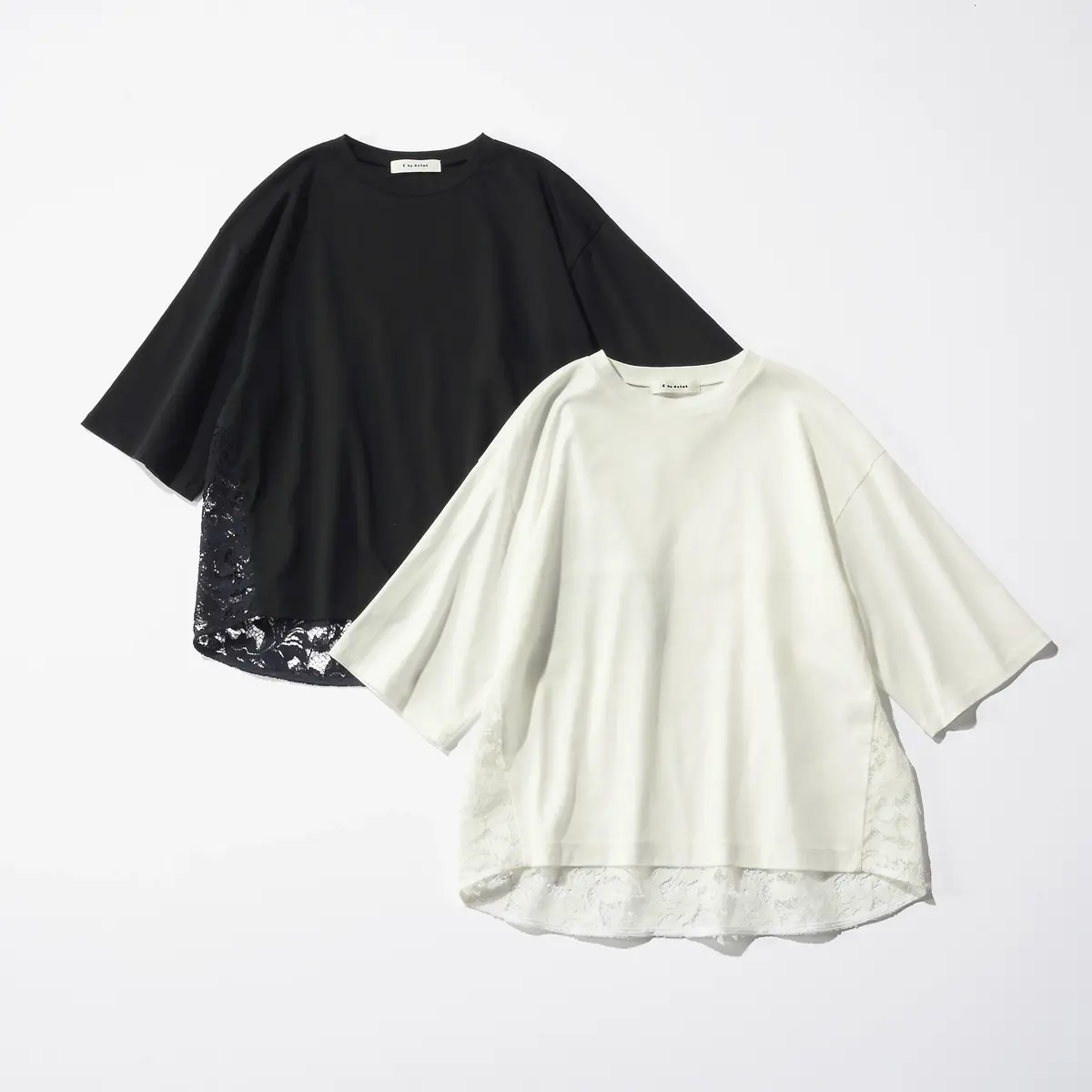 黒と白のゆったりとしたTシャツ2枚が並んでいる。裾部分に繊細なレースがあしらわれている。背景は白。ブランドロゴ「CINQUANTA」がタグに付いている。
