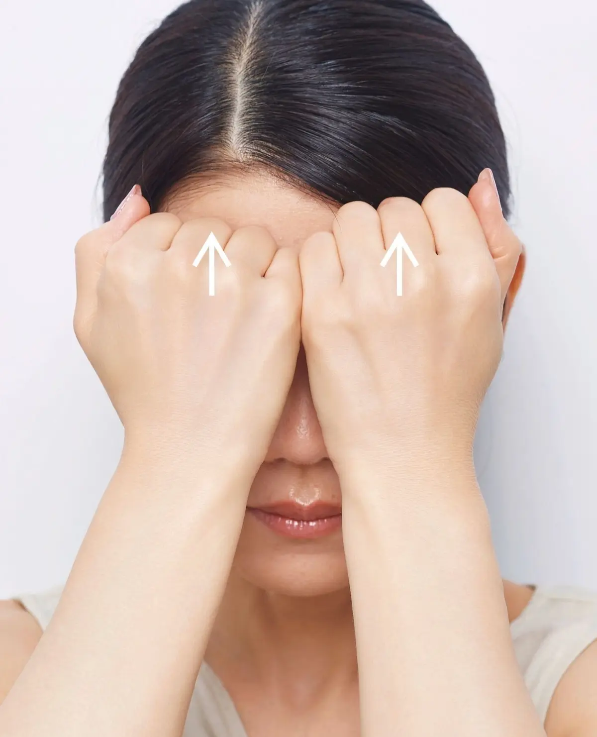 若い女性が両手で顔を覆い、困ったような表情をしているポートレート。背景は白。