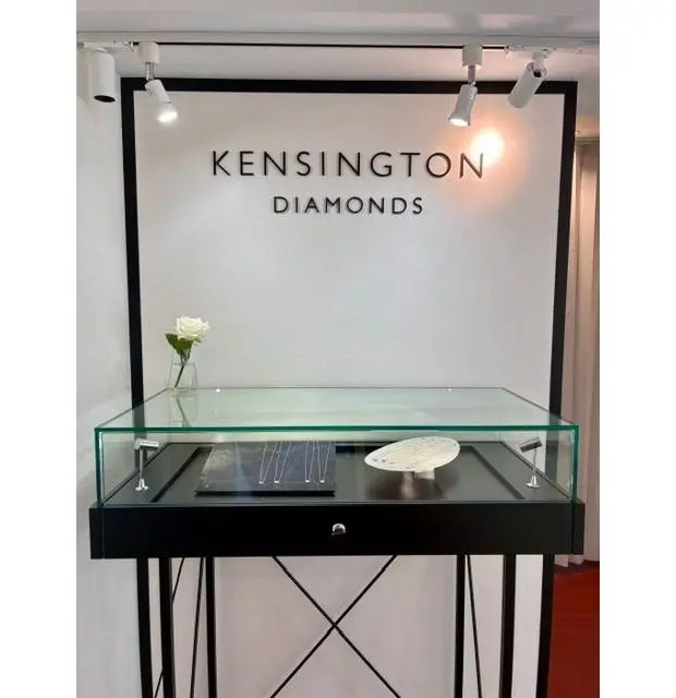 KENSINGTON DIAMONDSのディスプレイ台、ガラス棚に宝石と白い花が置かれている