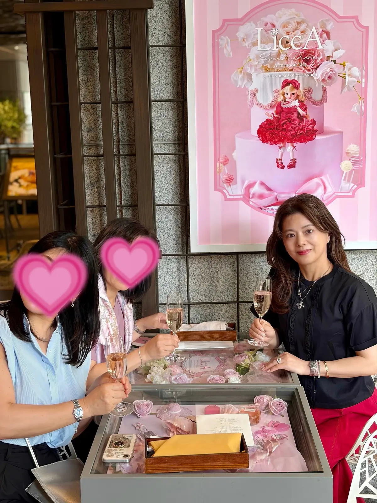 「LiCCA」のロゴとリカちゃん人形が飾られたフレームが背景にあり、3人の女性がシャンパングラスを手に笑顔で並んでいる。