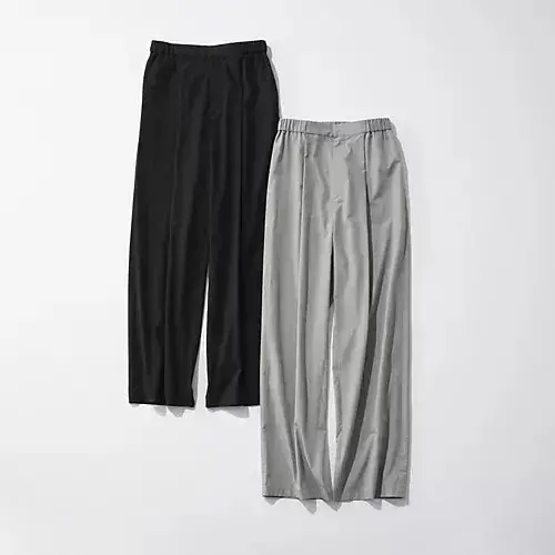 黒とグレーのゆったりとしたパンツが壁に立てかけられている。ウエストはゴム仕様で、シンプルなデザイン。