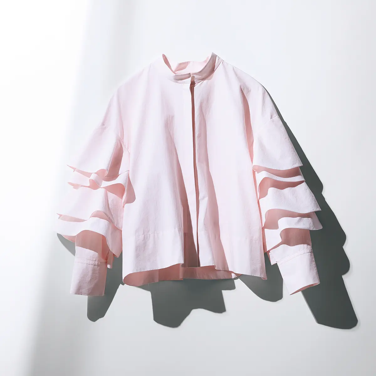 袖にランダムに重ねられたラッフルフリル