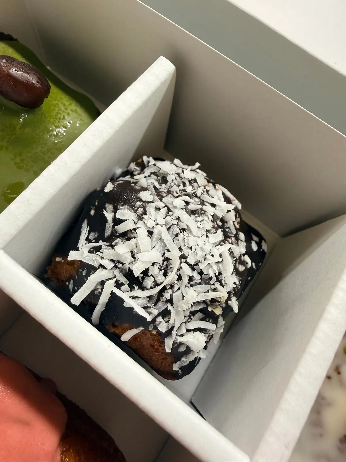 白いトレイに、チョコレートコーティングされたココナッツフレークをトッピングしたデザートが置かれています。