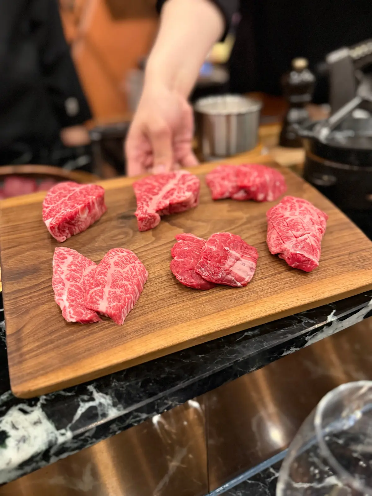 木製のボードに並べられた6枚の赤身肉、鮮やかな赤色と白い脂肪が目立つ。