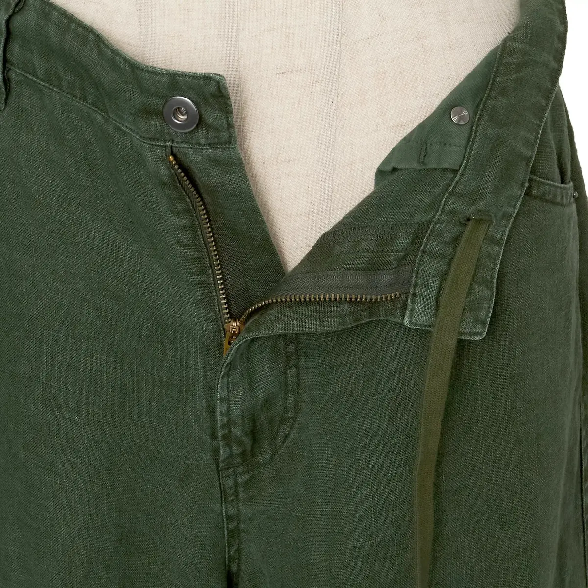 緑色の軍服の前面部分で、ファスナーとボタンが付いたポケットが特徴です。