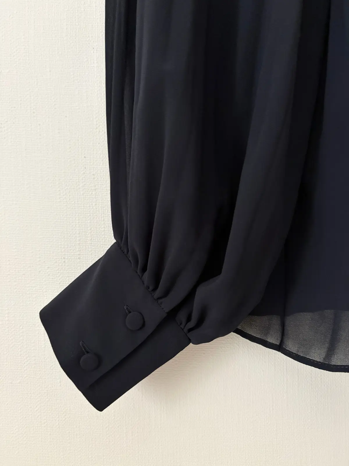 リュンヌのプリーツブラウス　袖口のくるみボタン