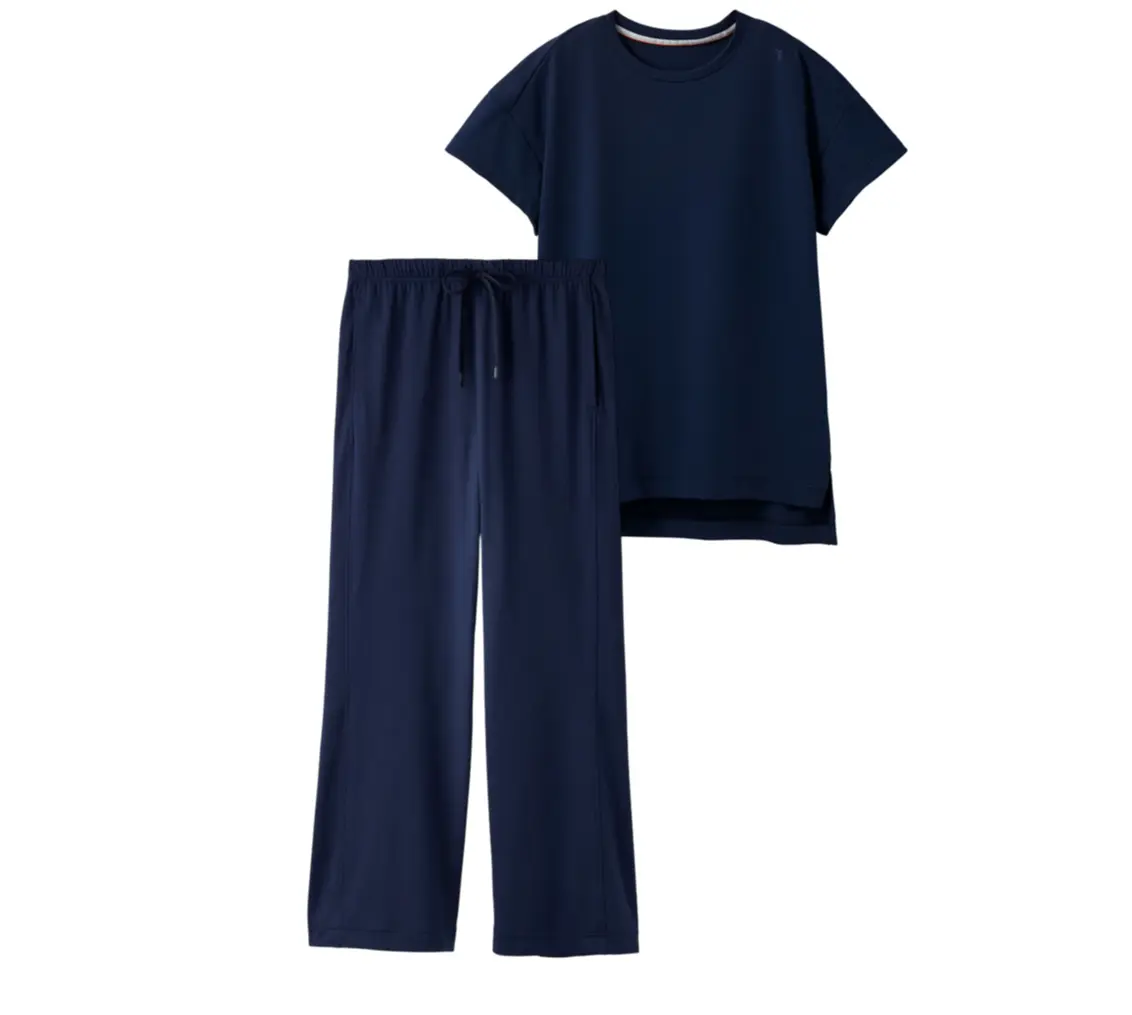 濃紺色の、Tシャツとパンツのセットアップ。Tシャツはゆったりとしたシルエットで、パンツはドローコード付きのストレートレッグ。白い背景に、Tシャツが右、パンツが左に配置されている。