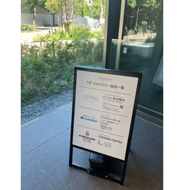 木目調の長いカウンターバーと、その奥のエスプレッソマシンが見えるカフェの内部。天井には配管や照明器具、数字のネオンサイン「1909」がある。カウンターの上にはグラスやビールサーバーが並び、手前にいくつかの瓶が置かれている。