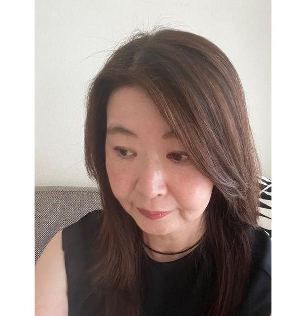 茶色の髪を肩まで伸ばした女性が、正面やや右を向いてこちらを見ているポートレート。黒いチョーカーを着用し、黒いトップスを着ている。背景は白と黒の模様のソファ。