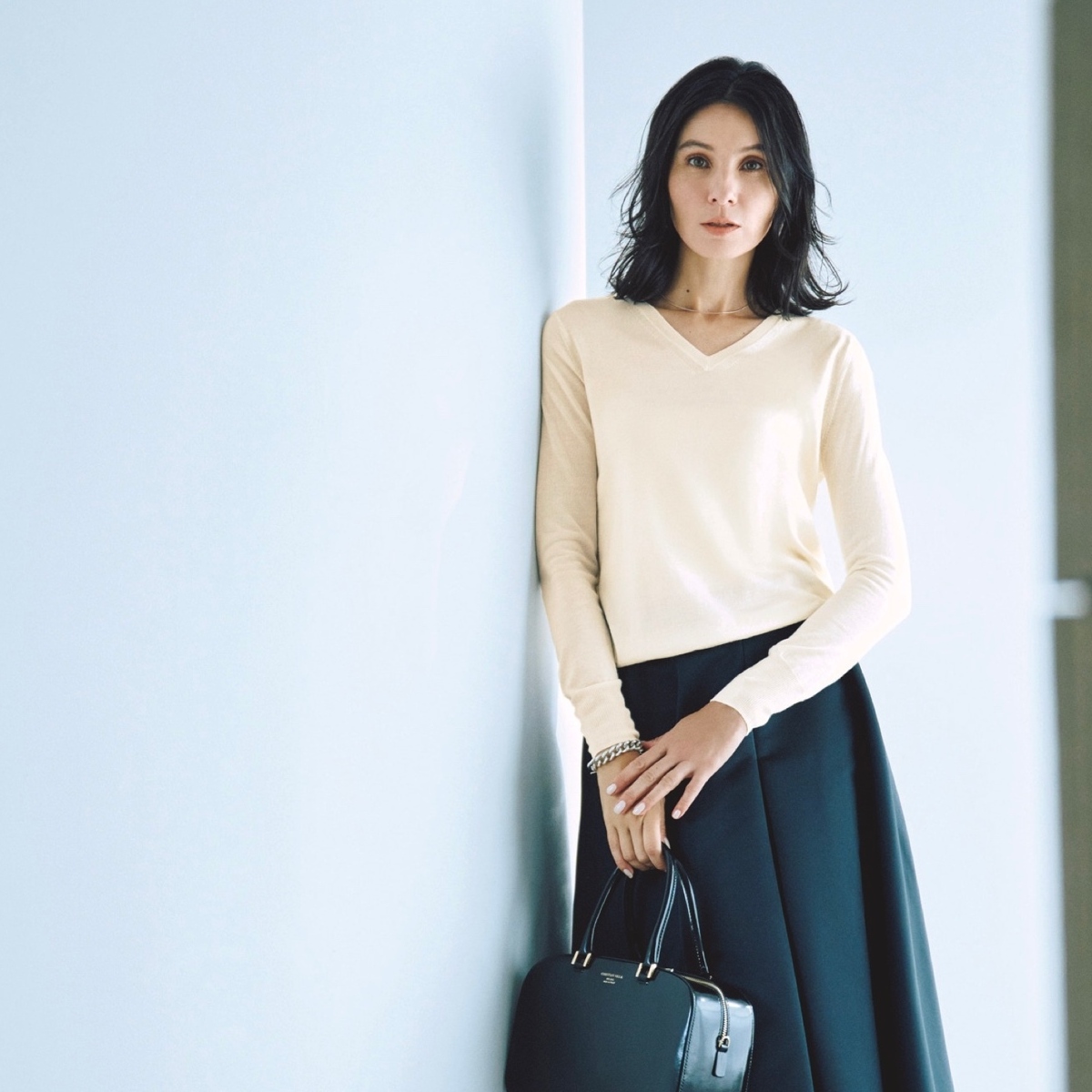 黒フレアースカートの存在感で、プレーンなエクリュニットとのモノトーンコーデを印象的に。最低気温8℃｜3/4(水)【40代・50代の毎日コーデ】