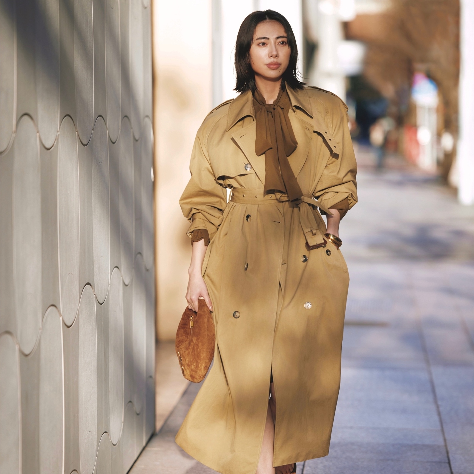 ベルトを締めてドレスのようにまとったトレンチコートから、ブラウスのボウタイをのぞかせてドラマティックさを上昇！気温18℃｜4/10(金)【40代・50代の毎日コーデ】