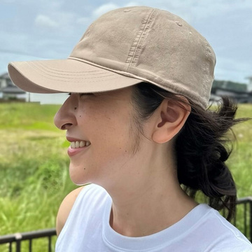 【これが正解！50代の帽子がこなれて見えるヘアアレンジ#2】カジュアルなキャップに、華シニヨンで女らしさをプラス