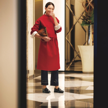 赤ニットドレス×デニムパンツのレイヤードコーデはクラシックなローファーでリュクスに引き締め。最低気温9℃｜11/21(金)【50代の毎日コーデ】