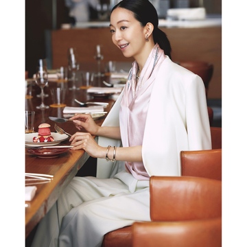 ブラウスとスカーフのピンクの艶で上品な色香を漂わせてビジネスシーンの装いをモダンに彩る。気温30℃｜6/16(月)【50代の毎日コーデ】