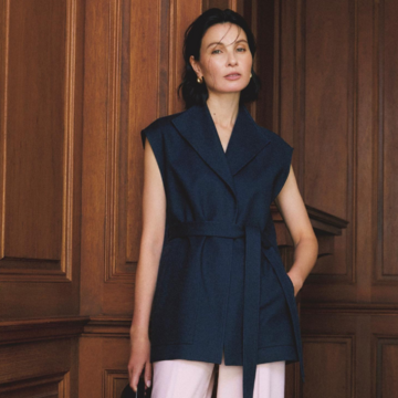 甘やかな淡ピンクパンツを引き締めるネイビーのベストを合わせて凛としたムードを演出。最高気温33℃｜7/4(金)【50代の毎日コーデ】