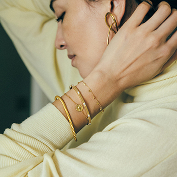 存在感のあるゴールドのブレスレットは“質感違い”の重ねづけでがおすすめ