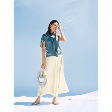 ツヤめく淡イエロースカートには、無機質なグレーのトップスを合わせて都会的なフェミニンコーデに。気温30℃｜7/11(木)【50代の毎日コーデ】