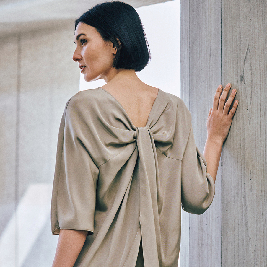 背中で魅せるドラマティックなブラウス。50代の夏ファッションにふさわしい「素肌を感じる服」