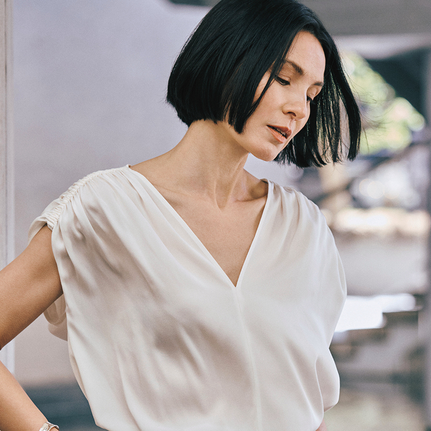 Vラインのブラウスでデコルテをアピール。50代の夏ファッションにふさわしい「素肌を感じる服」